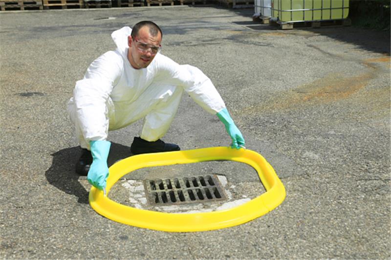 Barrage d'obturation jaune Plastibarre en polyuréthane bloquant une fuite de liquide devant un fût bleu.