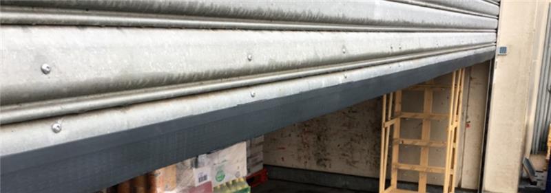 Rouleau de 5 mètres de joint RAXIT noir avec bande orange de protection, montrant la structure ondulée du joint d'étanchéité anti-rongeurs.